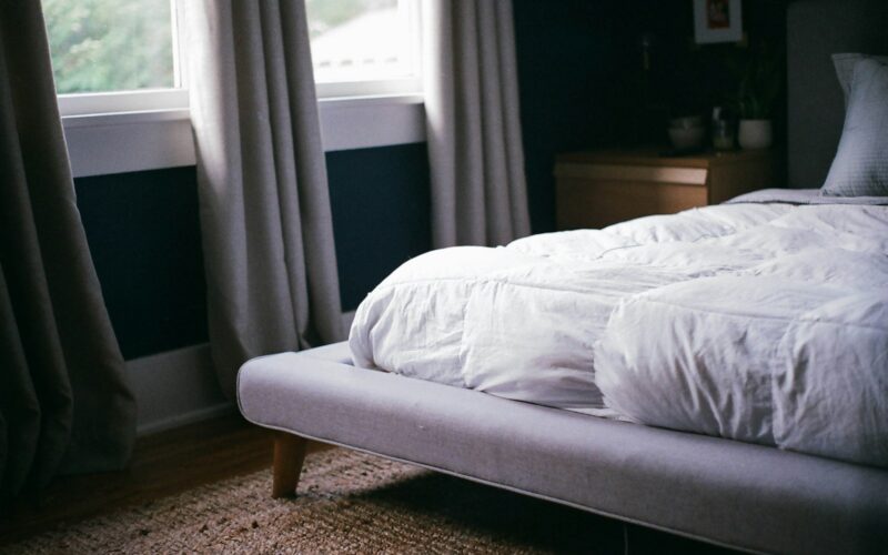 white bed by the window during daytime